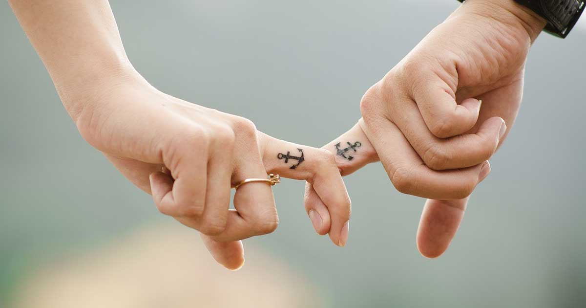 Bild zeigt Hände eines Paares mit Anker-Tattoo