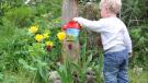 Bild zeigt Kind mit Gießkanne das im Garten spielt